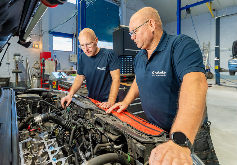 Mechanic performing maintenance on vehicle.